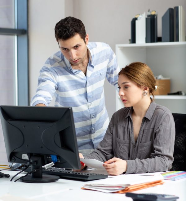 front-distanced-view-young-beautiful-lady-grey-shirt-talking-discussing-something-with-young-man-inside-office-daytime-building-job-activity (1) (1)